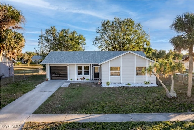 single story home with a garage and a front lawn