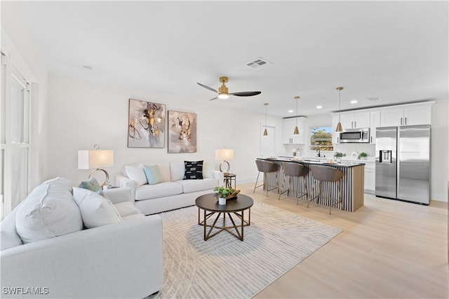 living room featuring ceiling fan and light wood-type flooring