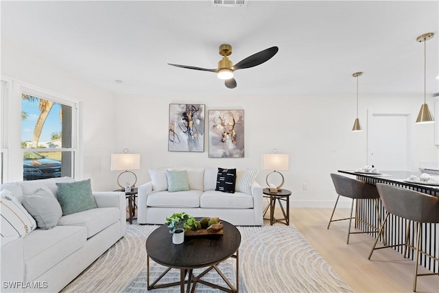 living room with ceiling fan and light wood-type flooring