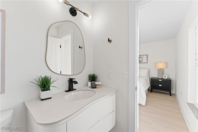 bathroom featuring toilet, vanity, and hardwood / wood-style flooring