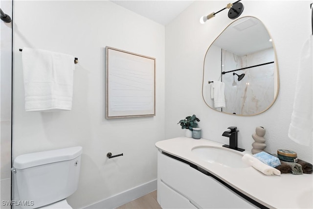 bathroom featuring a shower, vanity, and toilet