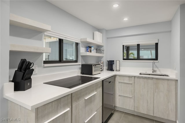 kitchen featuring stainless steel dishwasher, black electric stovetop, sink, and light tile patterned floors