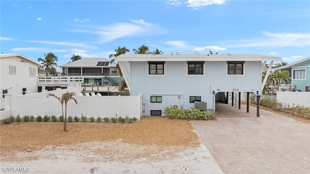 rear view of house with central AC unit and a carport