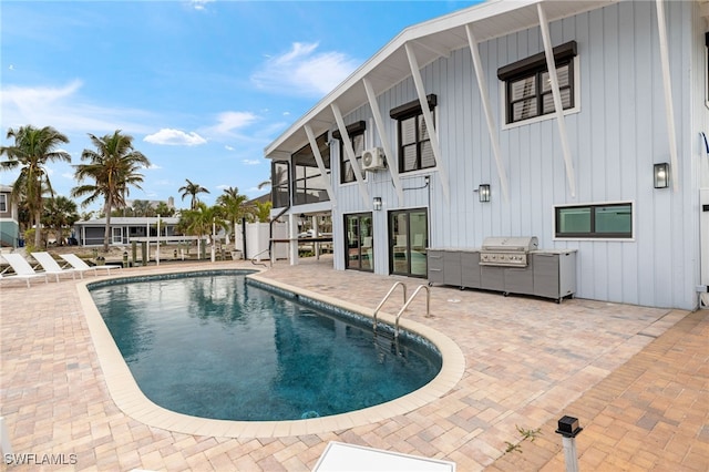 view of swimming pool featuring area for grilling and a patio