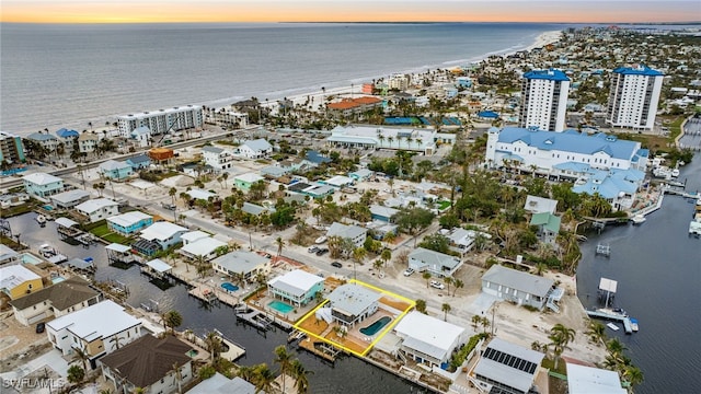 aerial view at dusk featuring a water view