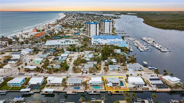 aerial view at dusk featuring a water view