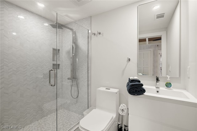 bathroom featuring a shower with door, vanity, and toilet