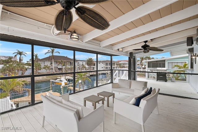 sunroom / solarium featuring beam ceiling and ceiling fan