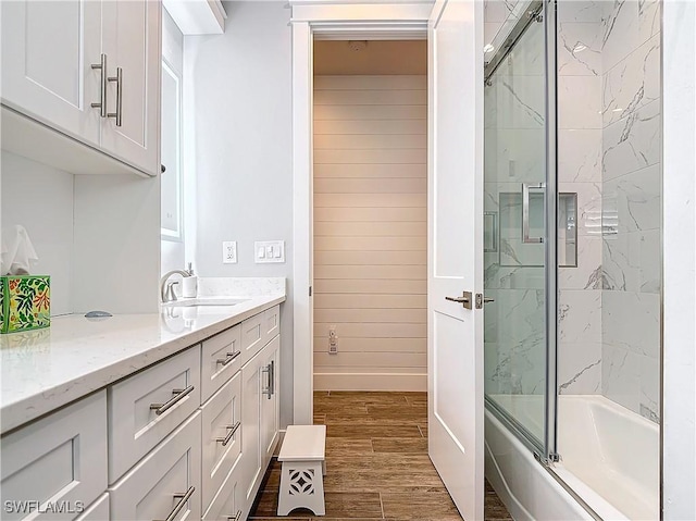 bathroom featuring enclosed tub / shower combo, vanity, and wood-type flooring