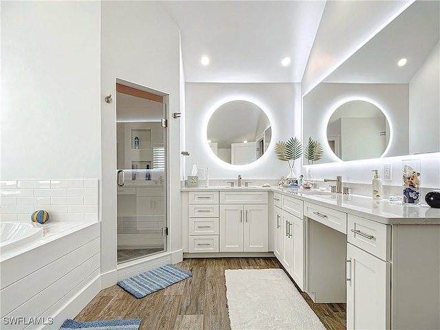 bathroom featuring hardwood / wood-style floors, vanity, shower with separate bathtub, and vaulted ceiling