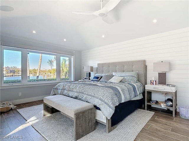 bedroom featuring ceiling fan and a water view