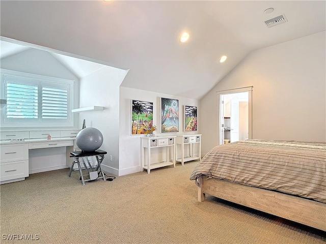 bedroom with a walk in closet, light colored carpet, and vaulted ceiling