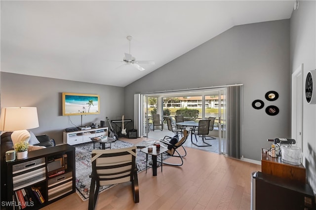 living room with light hardwood / wood-style floors, high vaulted ceiling, and ceiling fan