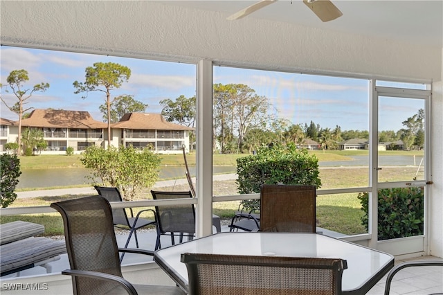 sunroom / solarium with a water view and ceiling fan