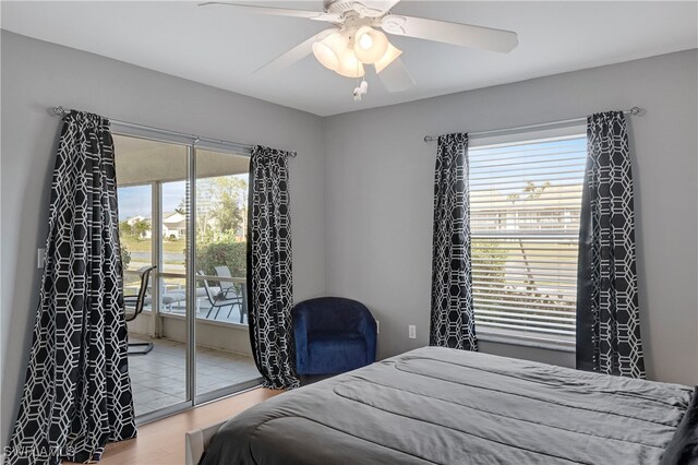 bedroom with wood-type flooring, access to outside, and ceiling fan