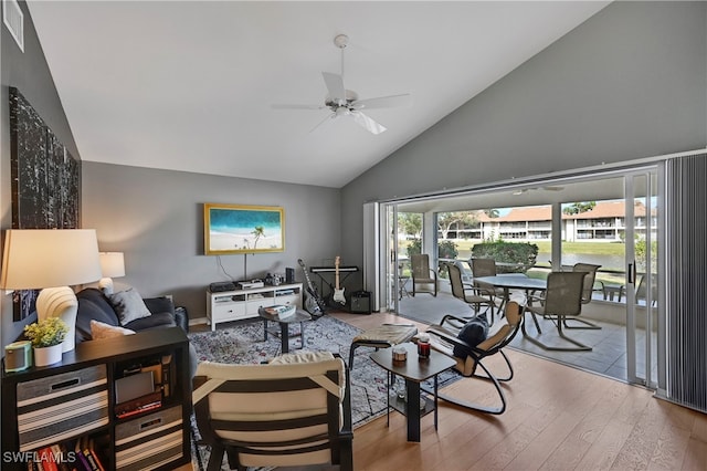 living room featuring ceiling fan, light hardwood / wood-style floors, and lofted ceiling