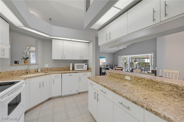 kitchen featuring white cabinetry, light stone countertops, white appliances, and sink