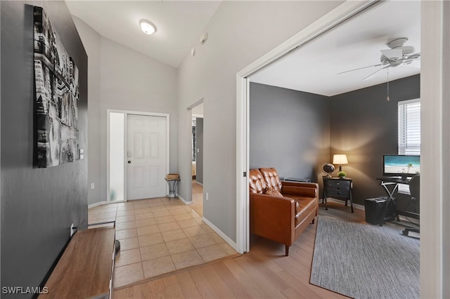 entryway with light hardwood / wood-style floors, ceiling fan, and lofted ceiling