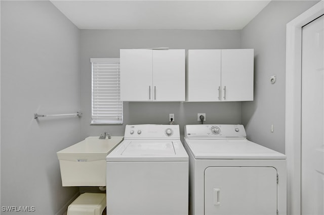 laundry area with cabinets, independent washer and dryer, and sink