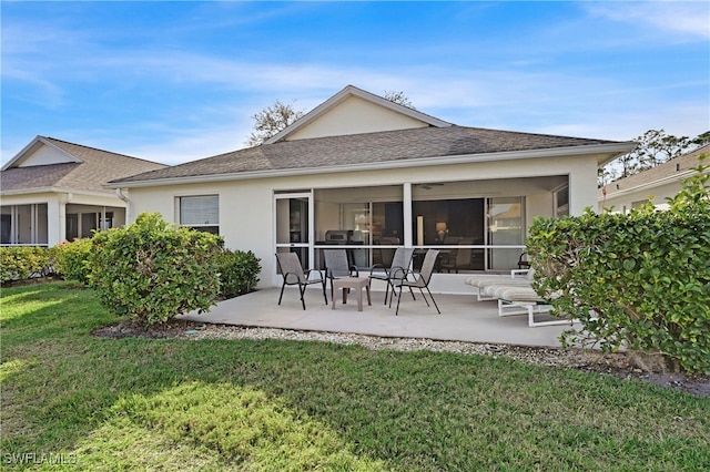 back of house featuring a lawn, a sunroom, and a patio area