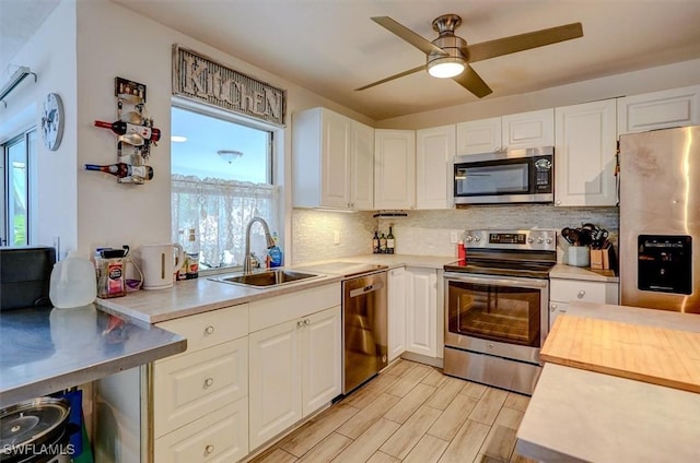 kitchen with sink, stainless steel appliances, a healthy amount of sunlight, and white cabinets