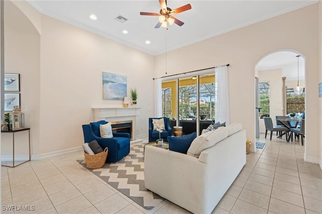 living room featuring ceiling fan, ornamental molding, and light tile patterned floors