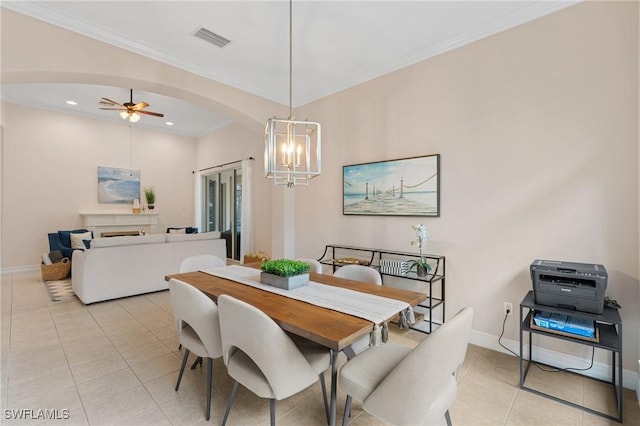 tiled dining space featuring ceiling fan with notable chandelier and ornamental molding