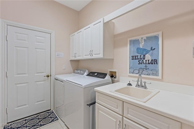 washroom featuring cabinets, light tile patterned flooring, washer and clothes dryer, and sink