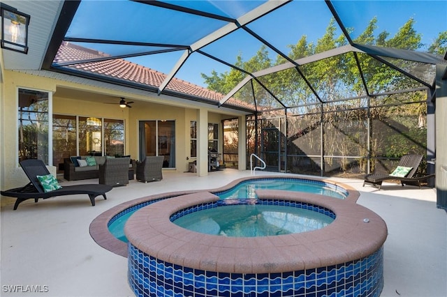 view of pool featuring an outdoor hangout area, a patio area, glass enclosure, and an in ground hot tub