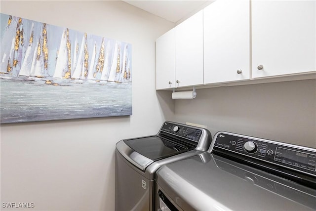 washroom with washing machine and clothes dryer and cabinet space