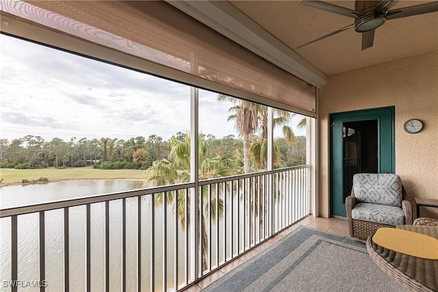 sunroom / solarium featuring a ceiling fan and a water view