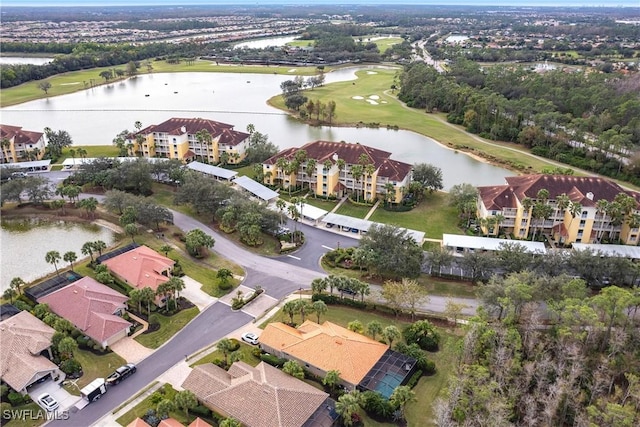 drone / aerial view with golf course view, a water view, and a residential view