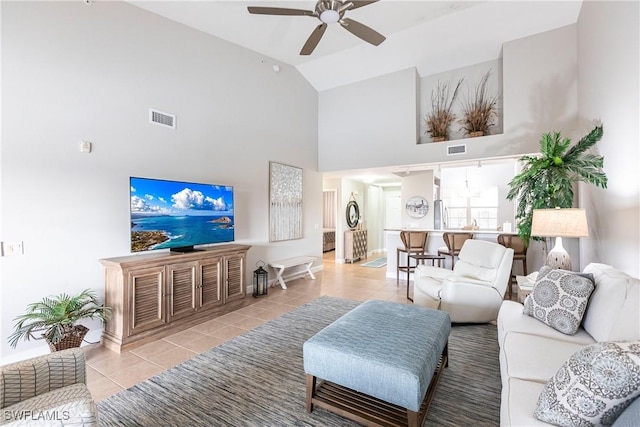 living room featuring tile patterned flooring, ceiling fan, visible vents, and high vaulted ceiling