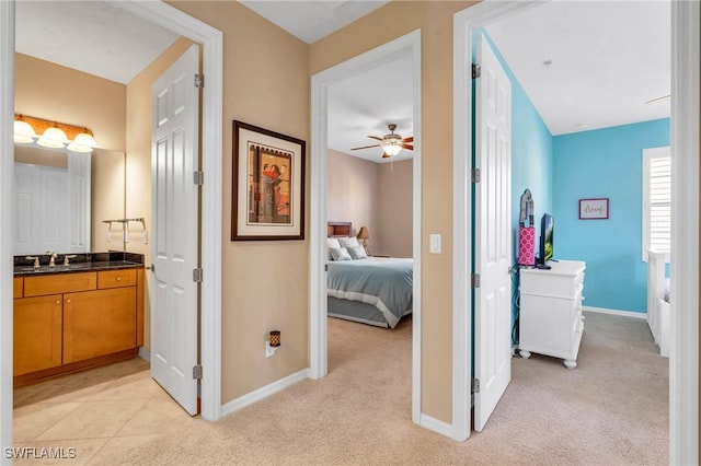 corridor featuring light colored carpet and sink