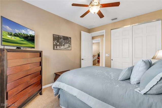 carpeted bedroom with ceiling fan and a closet