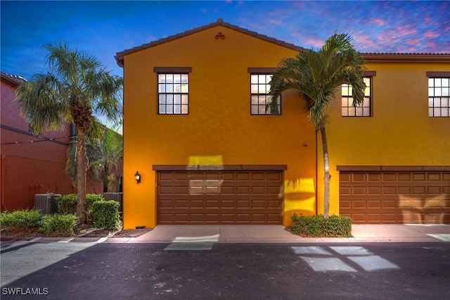 mediterranean / spanish house featuring central AC unit and a garage