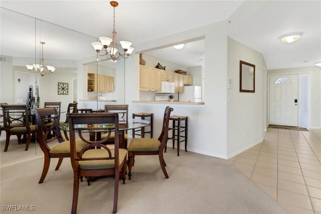 tiled dining room with a chandelier