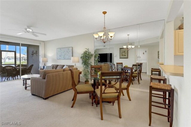 carpeted dining area featuring ceiling fan with notable chandelier