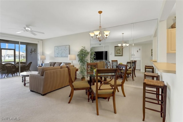 dining space featuring ceiling fan with notable chandelier and light colored carpet