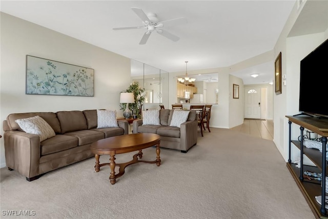 carpeted living room featuring ceiling fan with notable chandelier