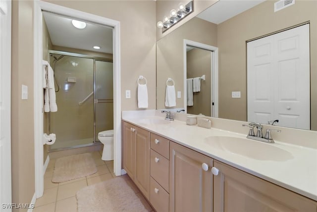 bathroom with tile patterned flooring, vanity, toilet, and walk in shower