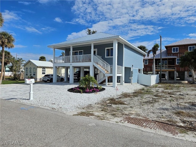 coastal inspired home with covered porch and a carport