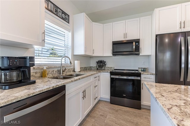 kitchen featuring white cabinets, sink, light stone counters, and stainless steel appliances