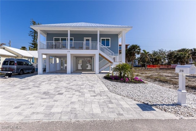 coastal inspired home with a carport and a porch