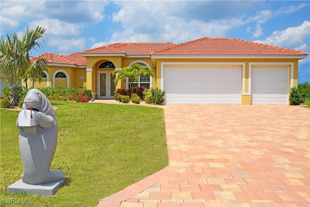 mediterranean / spanish-style home featuring french doors, a front yard, and a garage