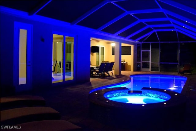 view of swimming pool featuring glass enclosure, an in ground hot tub, and a patio