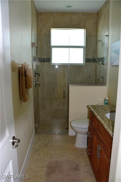 bathroom featuring toilet, vanity, tile patterned floors, and walk in shower