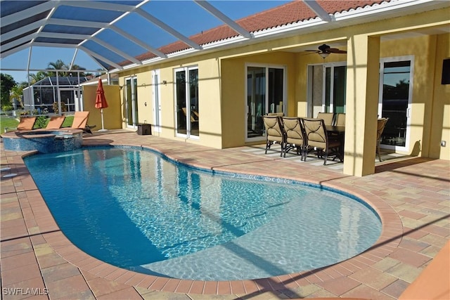 view of pool featuring glass enclosure, ceiling fan, and a patio