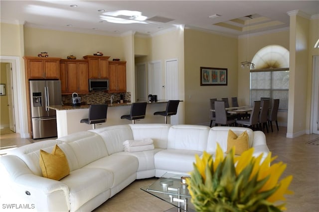 living room with crown molding and a towering ceiling