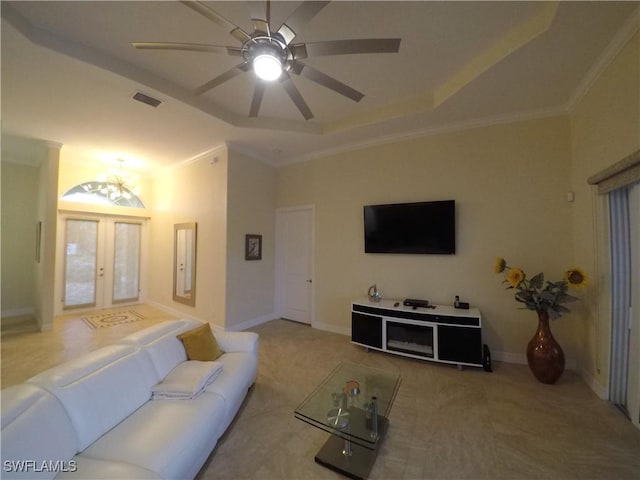 living room featuring ceiling fan, french doors, a raised ceiling, crown molding, and carpet